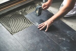 Tiles being installed in kitchen by installation professional 